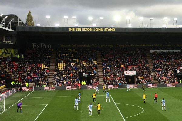 Partial view of the Sir Elton John Stand at Vicarage Road with the name displayed on the roof.