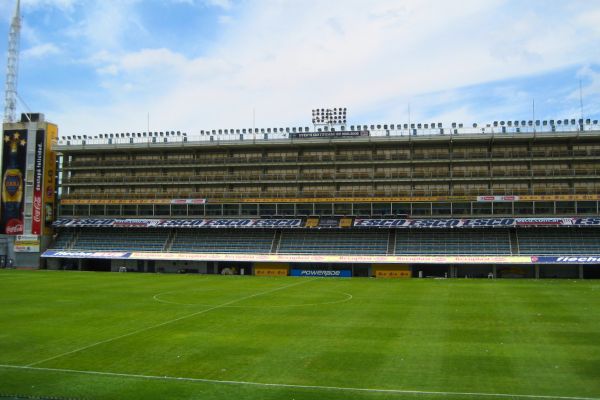 The lateral boxes of La Bombonera stadium, with rows of private seating areas extending along the side of the pitch, showcasing the stadium's steep and compact architecture.