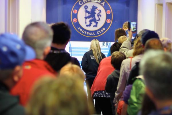 Tour group walking down the players' tunnel at Stamford Bridge stadium.