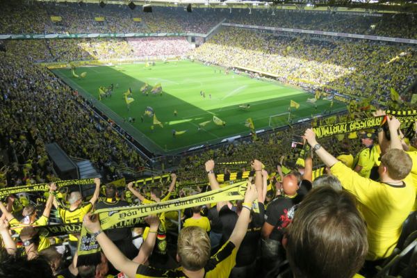 View of Borussia Dortmund fans holding scarves on the Yellow Wall at Signal Iduna Park.