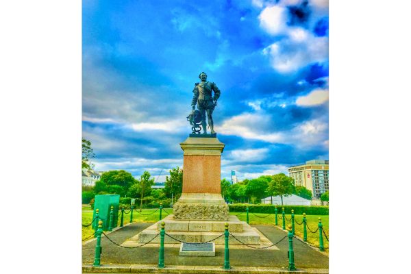 Statue of Sir Francis Drake overlooking Plymouth Hoe, depicted in naval attire and holding a sword.