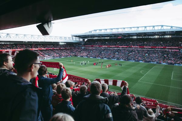 Liverpool fans holding up scarves at Anfield