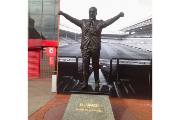 Statue of Bill Shankly outside Anfield Stadium, home of Liverpool FC, with arms raised in triumph.