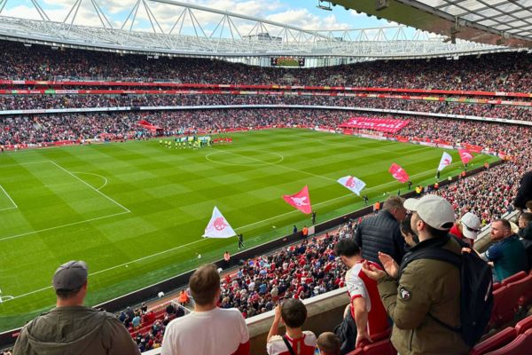 Spectators enjoying a football match inside Emirates Stadium, home of Arsenal FC.