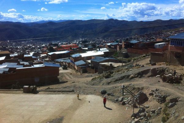 A panoramic view of the city of Potosí, with its colorful buildings and surrounding mountains under a clear blue sky.