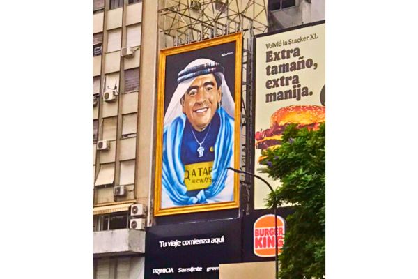 Mural of Diego Maradona in a headdress overlooking Avenida 9 de Julio in downtown Buenos Aires during the 2022 World Cup, symbolizing his enduring legacy.