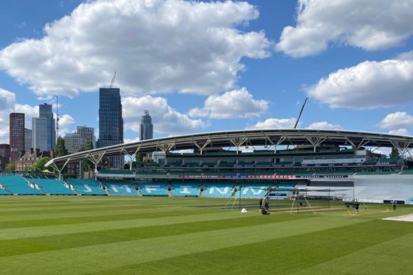 A modern view of The Oval cricket ground, featuring contemporary facilities, lush green pitch, and the iconic pavilion against a clear blue sky.