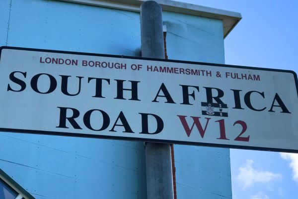 Close-up of the South Africa Road street sign outside Loftus Road Stadium.