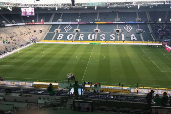 View of Borussia Park stand showcasing white seats with 'Borussia' text during a matchday.