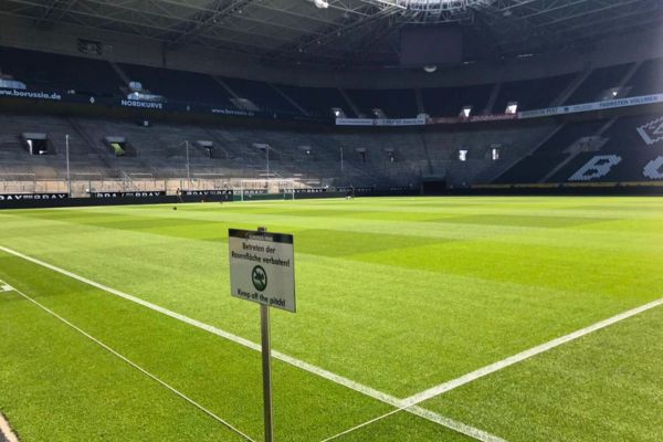 Pitchside view at Borussia Park with standing terraced section visible behind the goal.