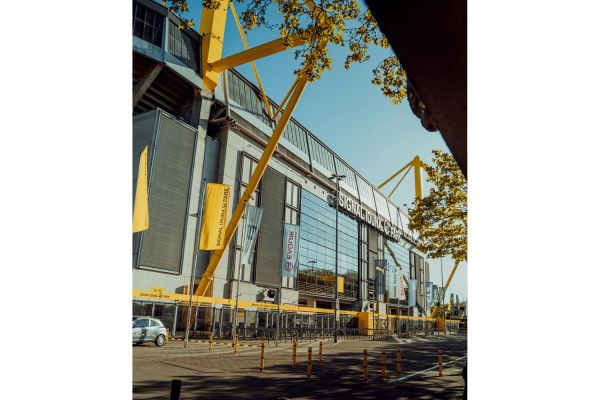 Exterior view of Signal Iduna Park in Dortmund, Germany, showcasing its iconic yellow pylons and modern architectural design.