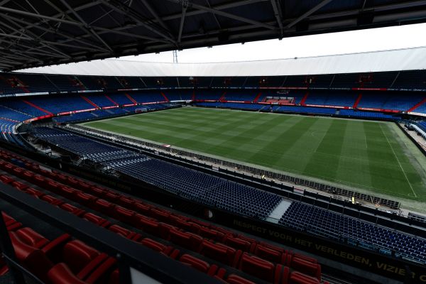 Interior view of an empty Feyenoord Stadium, also known as De Kuip, in Rotterdam, Netherlands, highlighting its classic bowl design and seating layout.