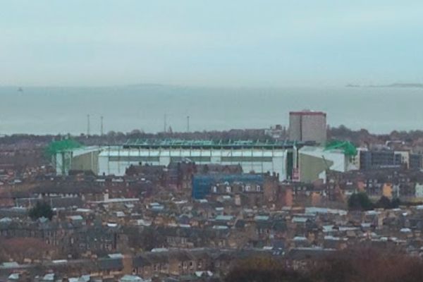 View of the roof of Easter Road Stadium, towering over surrounding buildings in Edinburgh.