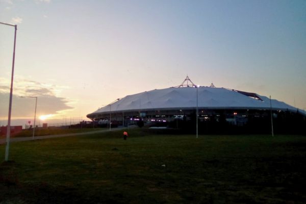 A view of Estadio Ciudad de La Plata illuminated at dusk.