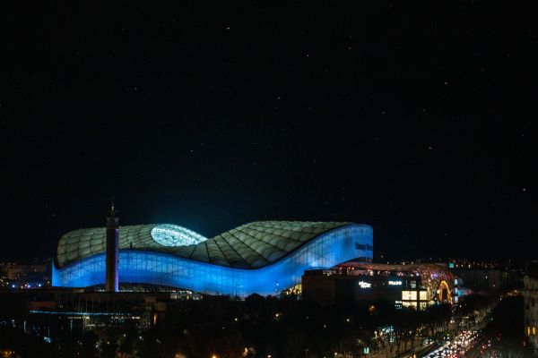 Stade Vélodrome illuminated in blue at night.