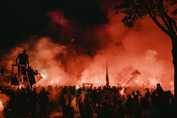 Marseille fans outside the stadium waving red flares in support of their team.