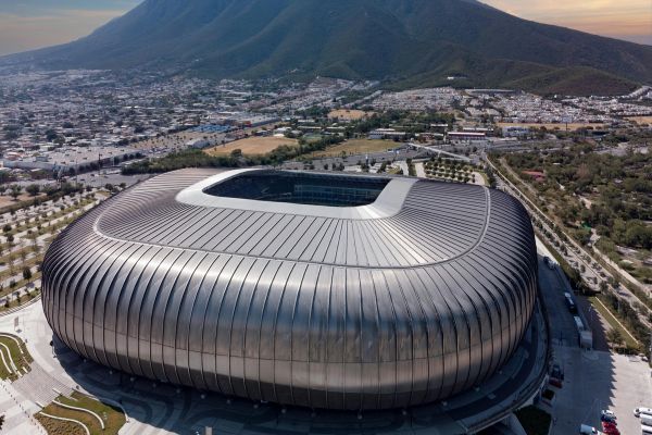 An aerial view of Estadio BBVA, showcasing its modern architecture and surrounding landscape in Monterrey.