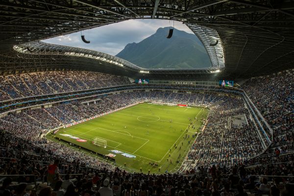 A full Estadio BBVA on matchday with the iconic Cerro de la Silla mountain in the background.