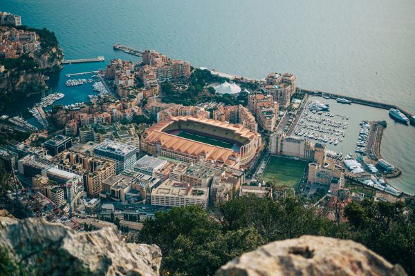 High aerial view of Stade Louis II in Monaco, nestled within the cityscape and near the Mediterranean Sea, highlighting its compact and scenic location.