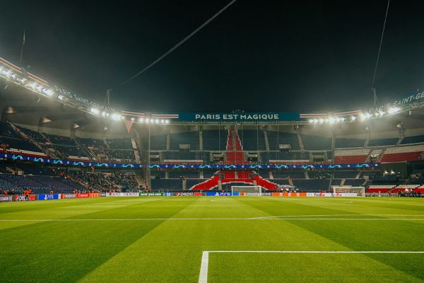 View from behind the goal at PSG’s Parc des Princes stadium under floodlights.