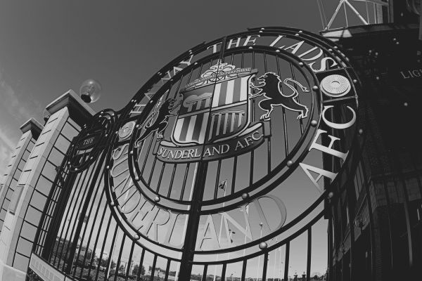 Black and white image of the gates outside Sunderland's Stadium of Light, featuring intricate designs and the club crest.