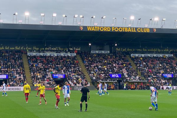 Referee officiating a match between Watford and Blackburn Rovers, managing the game with focus and authority.