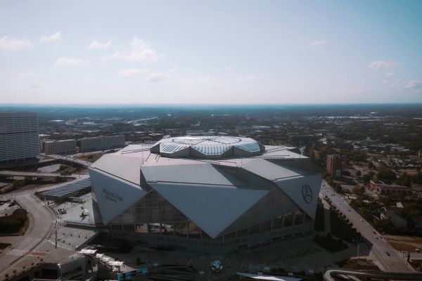 Aerial view of Mercedes-Benz Stadium in Atlanta, showcasing the unique retractable roof design and surrounding cityscape.