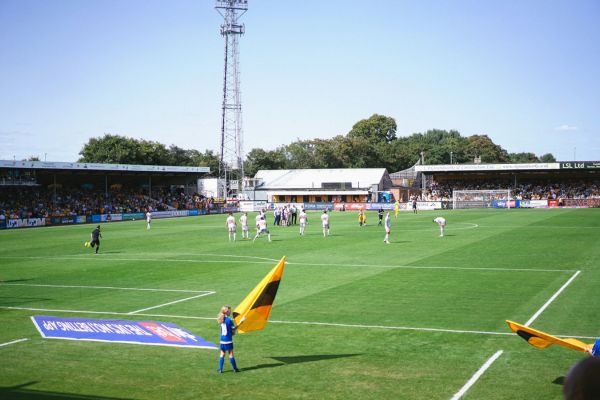 A of the field at Cledara Abbey Stadium on matchday, with players and fans in action.