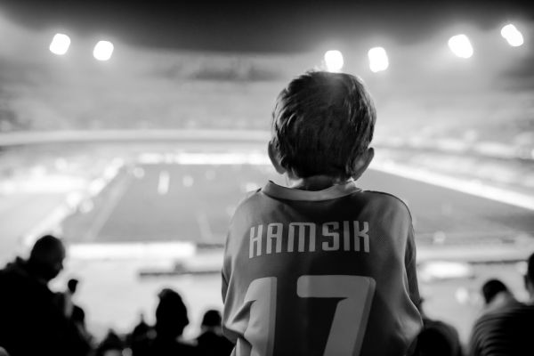 Black and white image of passionate SSC Napoli fans cheering in the stands during a matchday at Stadio Diego Armando Maradona.