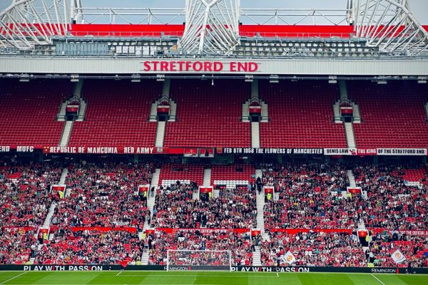 The Stretford End at Old Trafford, home of Manchester United, with fans in the stand.