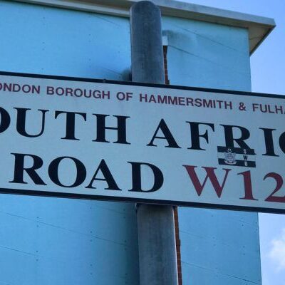 Close-up of the South Africa Road street sign outside Loftus Road Stadium.